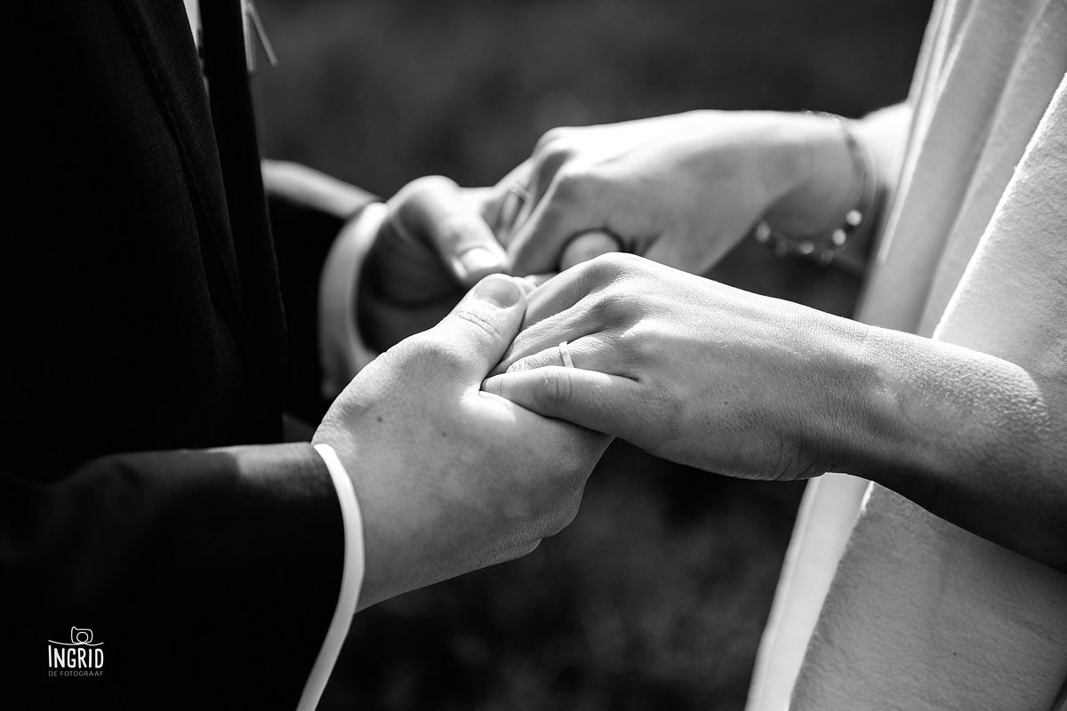 Bruid en bruidegom houden handen met trouwringen vast