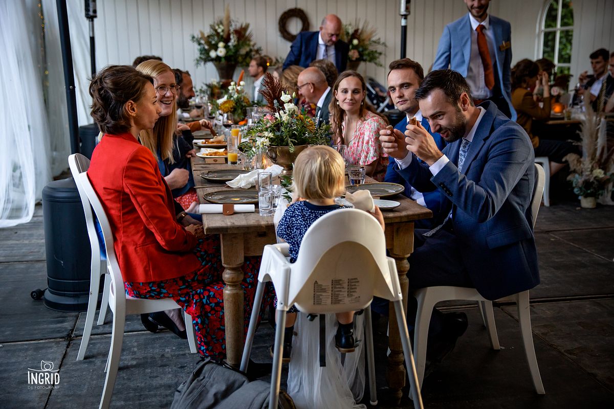 Gasten tijdens het bruiloft diner spelen met een frikandel Gasten tijdens het bruiloft diner spelen met een frikandel